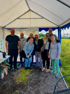 Gruppebillede af smilende mennesker i teltet under Sankt Hans-arrangement.
